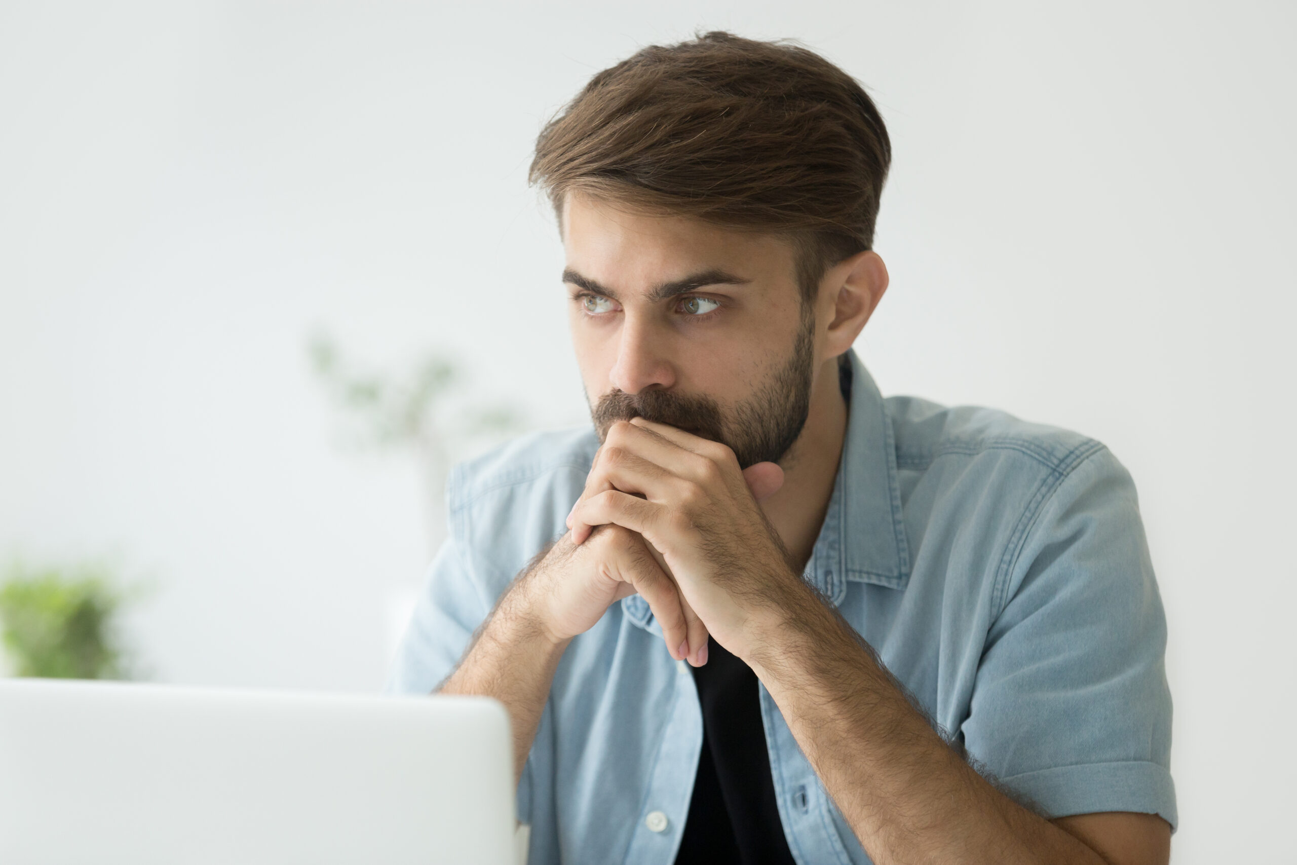 A focused man sitting in front of a laptop, deep in thought, symbolizing intense concentration, deep work, and achieving a state of flow.